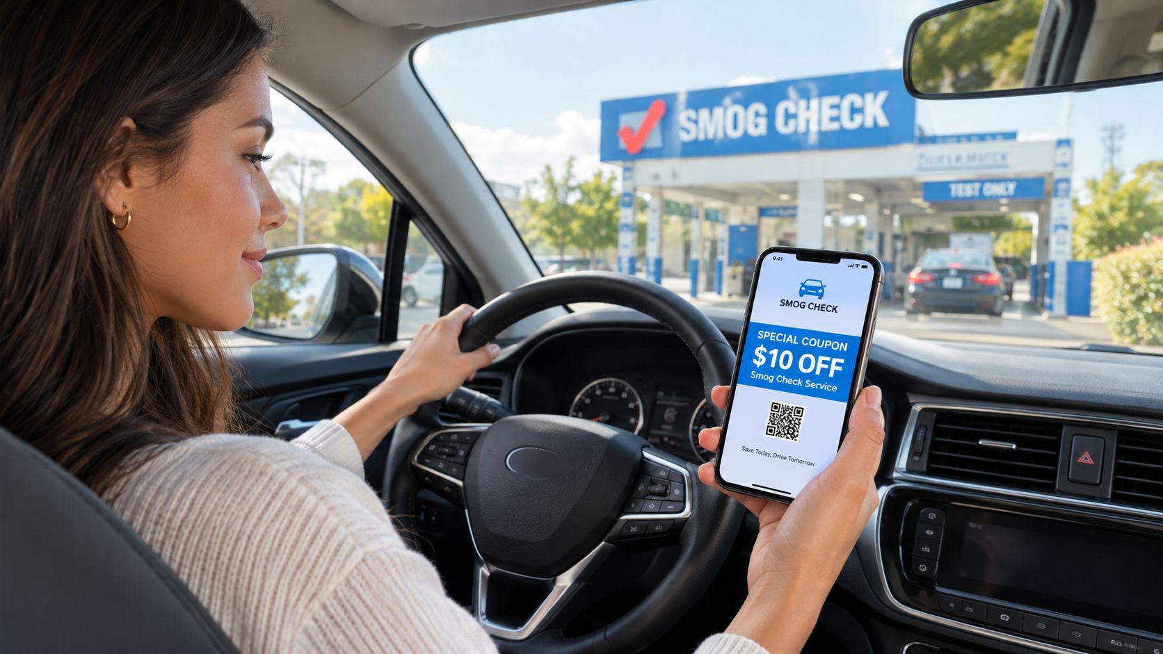 A woman driving a car holds a smartphone displaying a digital ten dollar off smog check coupon.